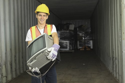 Worker wearing PPE handling waste during a waste removal operation