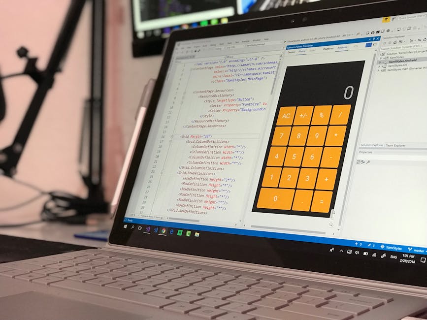 A close-up view of a laptop screen displaying lines of HTML and CSS code in a code editor window on the left side, with a simple calculator application featuring orange buttons and black display on th